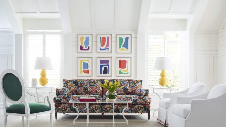 A beautifully designed living room featuring warm terracotta walls, a curved cream sofa, natural wood accents, and organic textures that promote comfort and emotional well-being.