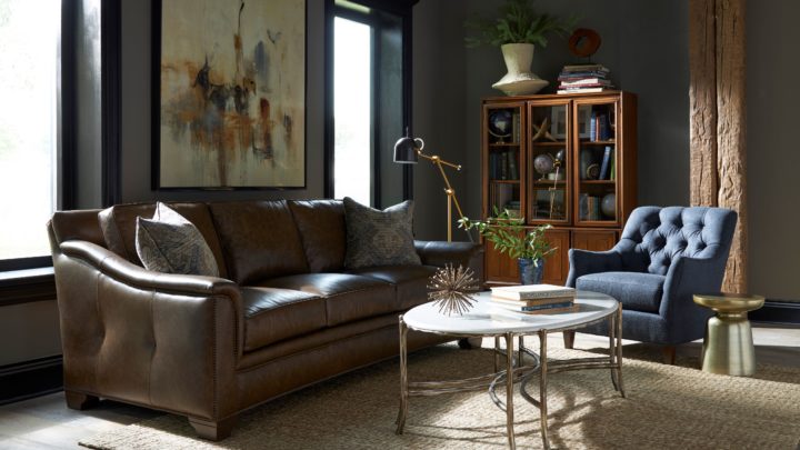 Cozy reading nook featuring a plush upholstered armchair, warm brass floor lamp, walnut side table, and soft neutral textiles inside Hickory Furniture Mart showroom.