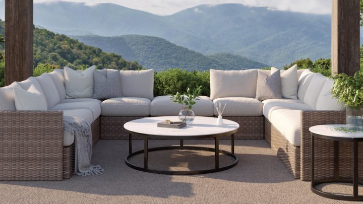 Beautiful outdoor patio dining table styled with linen runner, woven chargers, lanterns, and seasonal décor in a luxury backyard setting